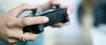 persona gioca con controller xbox in mano
