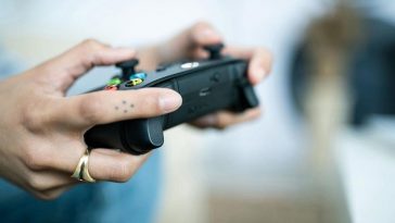 persona gioca con controller xbox in mano
