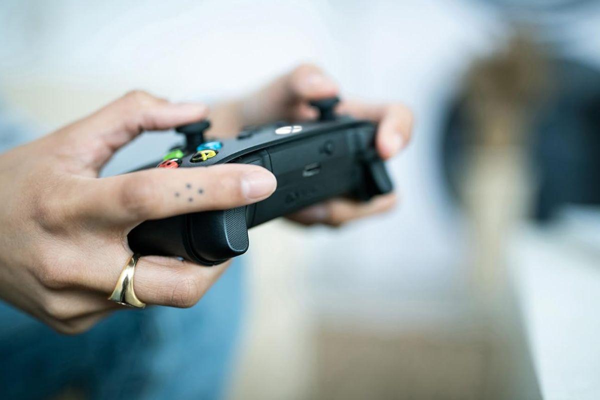 persona gioca con controller xbox in mano