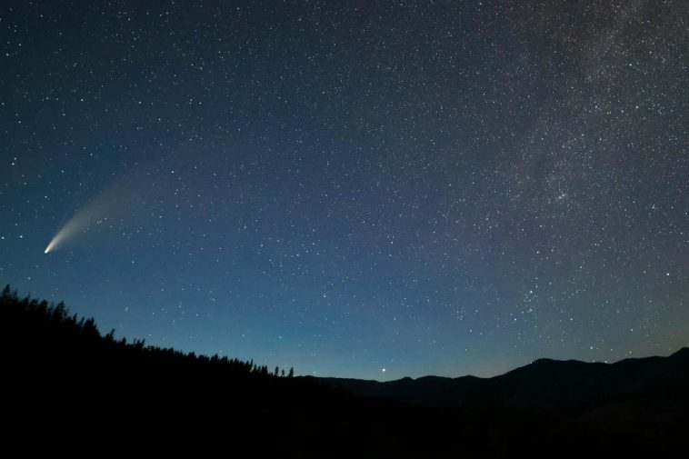 Un cielo stellato con una cometa