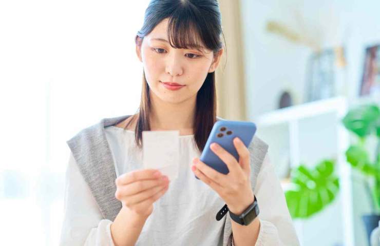 donna con foglietto e telefonino