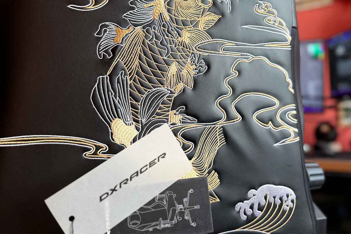 La scritta DxRacer del cartellino davanti al dettaglio ricamato della Carpa Koi