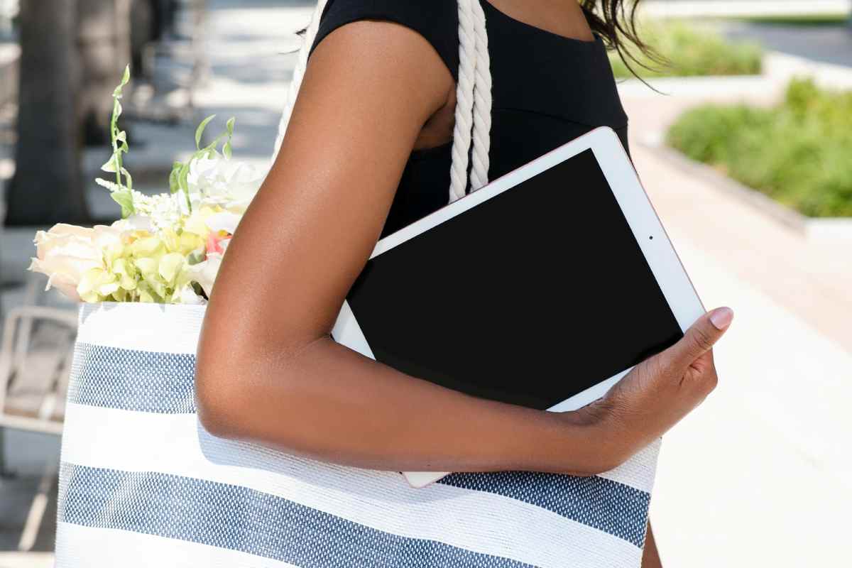 Una ragazza con un iPad vecchia generazione sotto il braccio