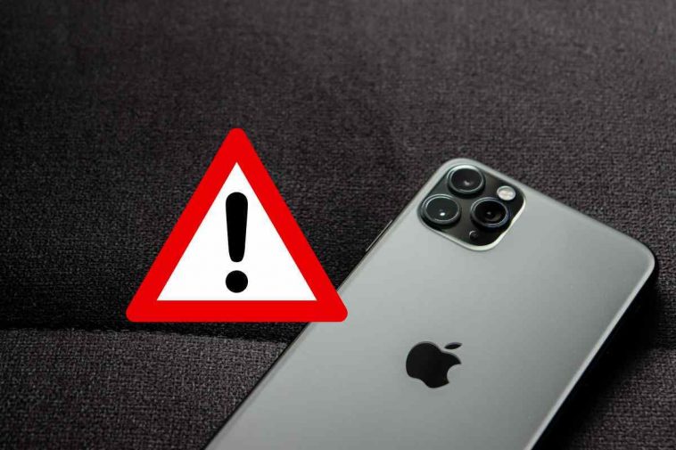 iphone grigio con simbolo di pericolo