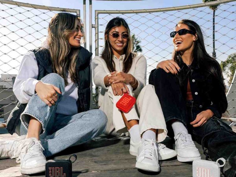 tre ragazze con occhiali da sole con in mano casse bluetooth
