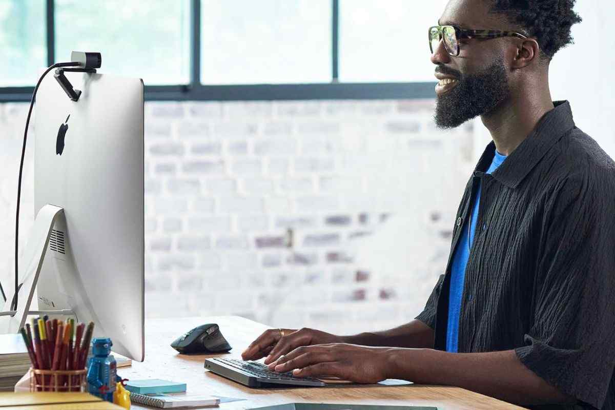 Logitech MX Keys Mini Tastiera Illuminata Wireless usata da uomo alla scrivania davanti a PC