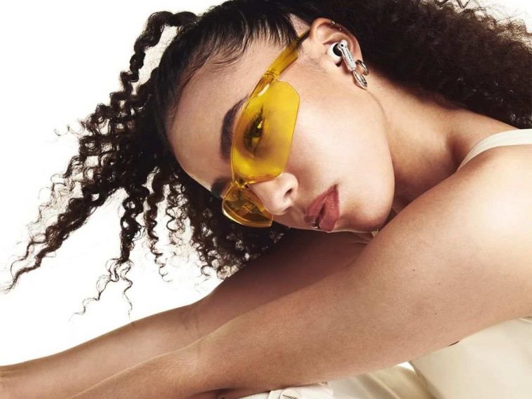 ragazza di profilo che indossa le cuffie nothing ear su sfondo bianco