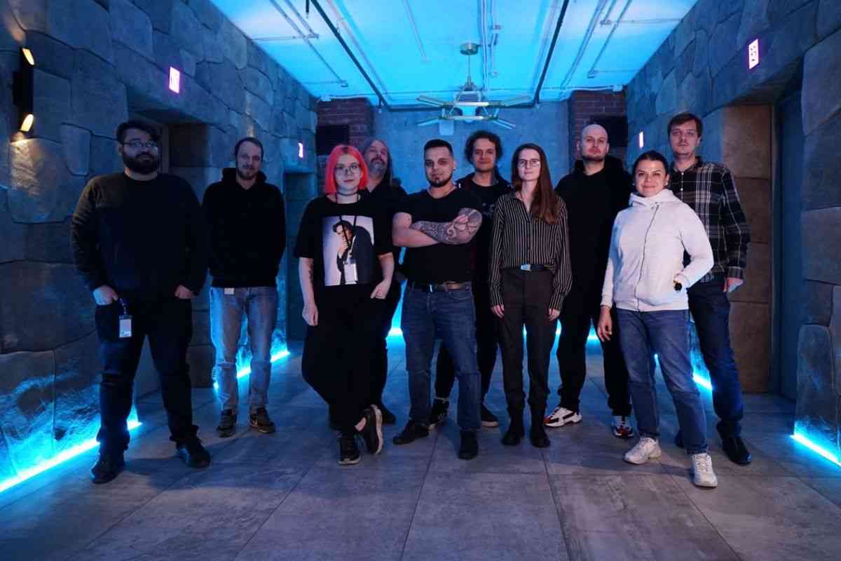 team di uomini e donna svluppatori di owlcat in piedi