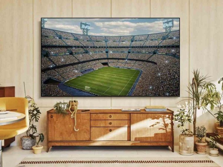Samsung Smart TV 50' appesa a muro con partita di calcio, mobile parete attrezzata, salotto con piante
