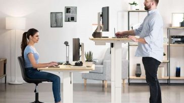 due persone che stanno utilizzando la scrivania regolabile homall da seduto e in piedi