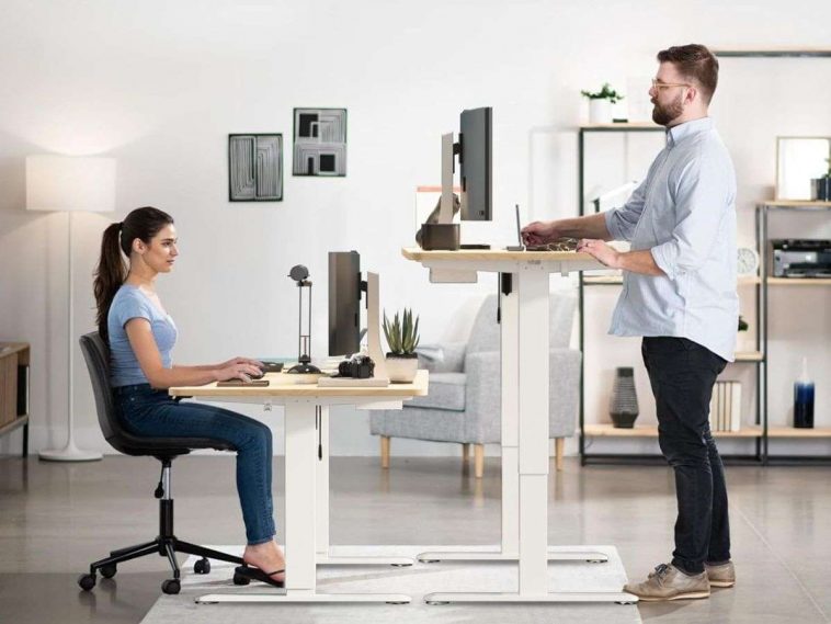 due persone che stanno utilizzando la scrivania regolabile homall da seduto e in piedi