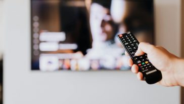 Una mano con telecomando che avvia una serie tv