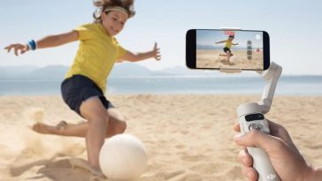 bambino che gioca a calcio sulla spiaggia ripreso da smartphone con stabilizzatore