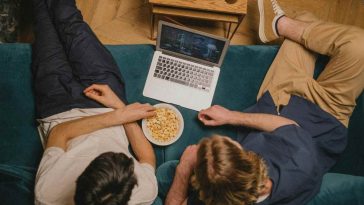 Due ragazzi che guardano serie tv in streaming dal laptop