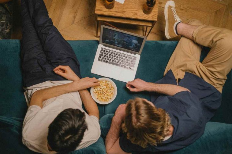Due ragazzi che guardano serie tv in streaming dal laptop