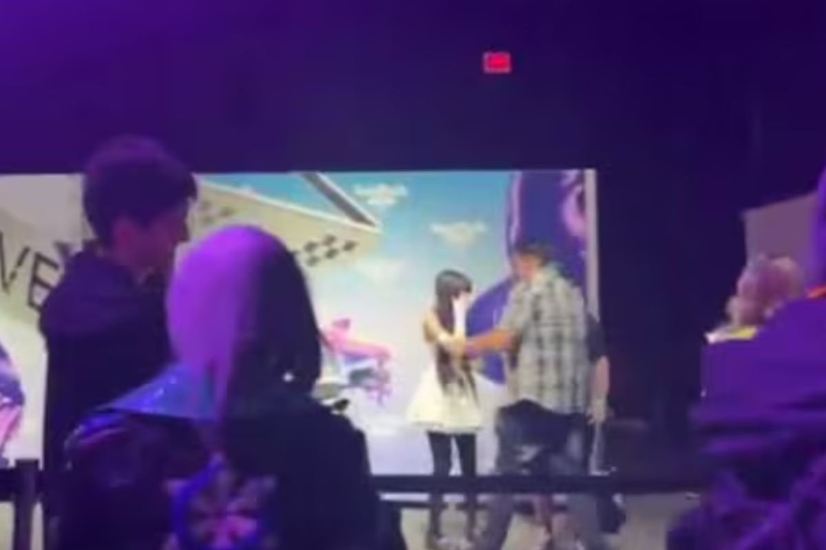 ragazza con vestito bianco aggredita da uomo con camicia a quadri