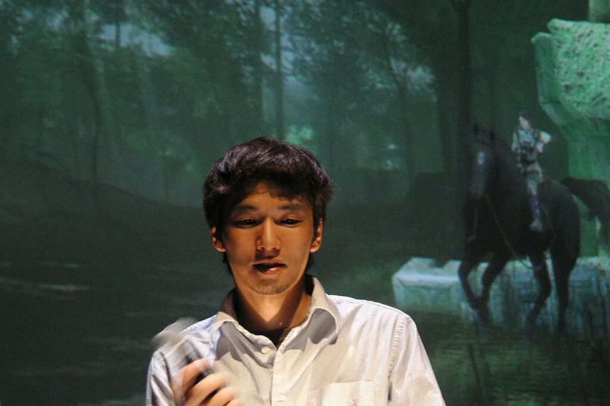 fumito ueda con camicia bianca, alle spalle ambientazione foresta con cavallo