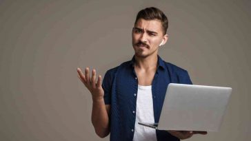 uomo sorpreso e triste con pc in mano