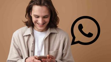 uomo che usa telefono con logo whatsapp