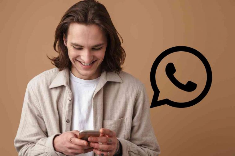 uomo che usa telefono con logo whatsapp