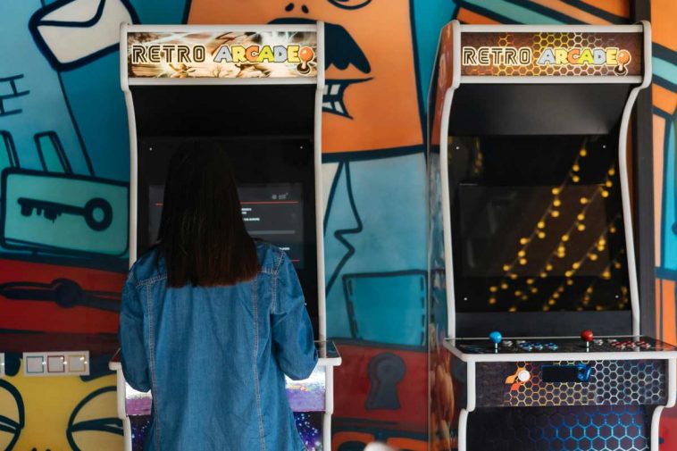 Una ragazza che gioca in una sala giochi con degli arcade