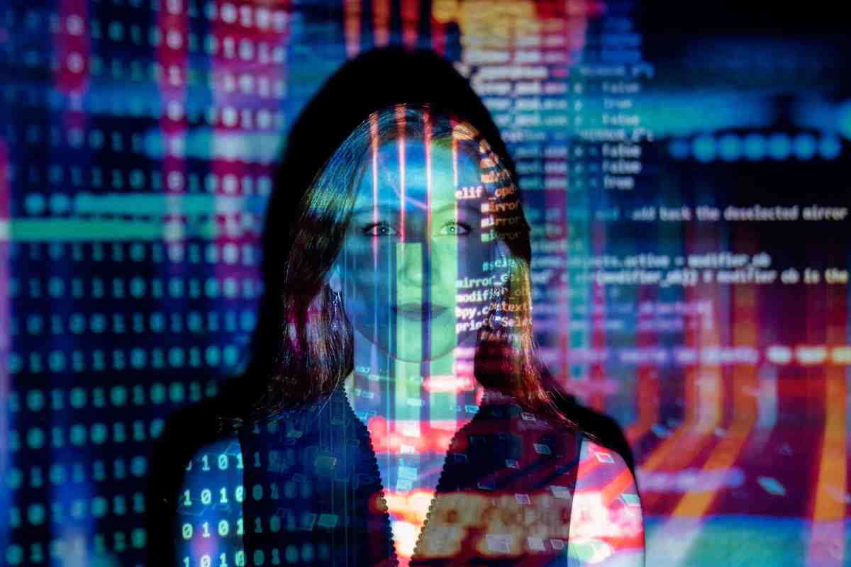 Una ragazza sul cui volto sono proiettati dei codici informatici