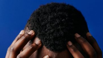 La testa di un ragazzo con i capelli ricci corti