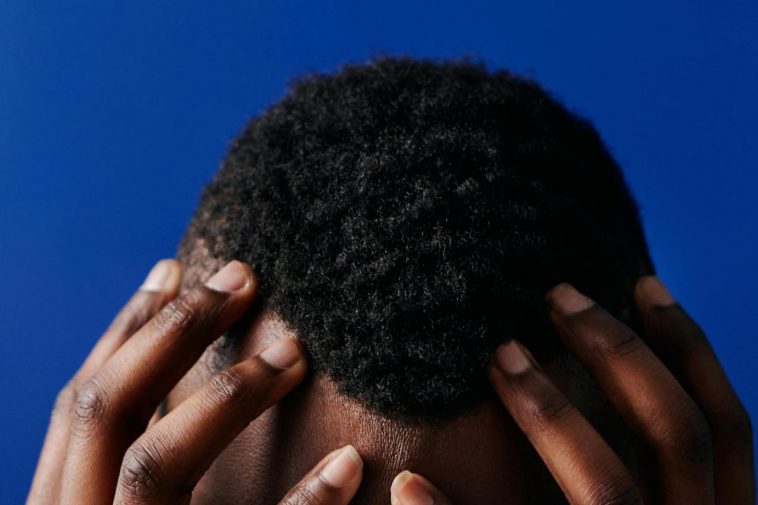 La testa di un ragazzo con i capelli ricci corti