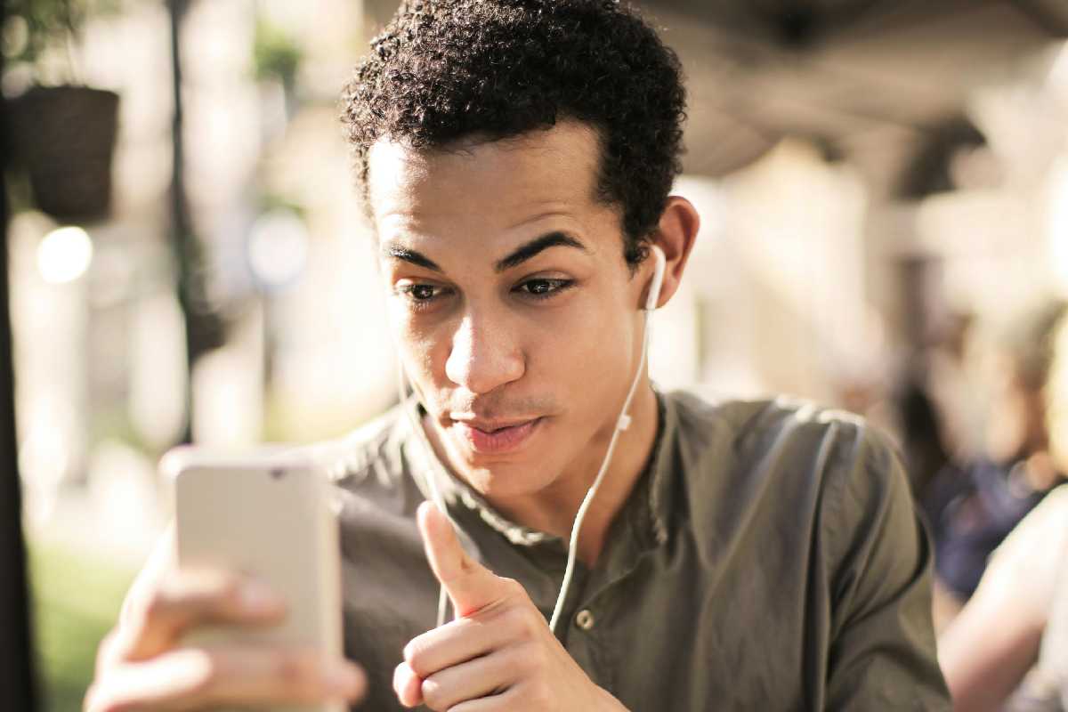 Un ragazzo con le cuffie e il telefono in mano