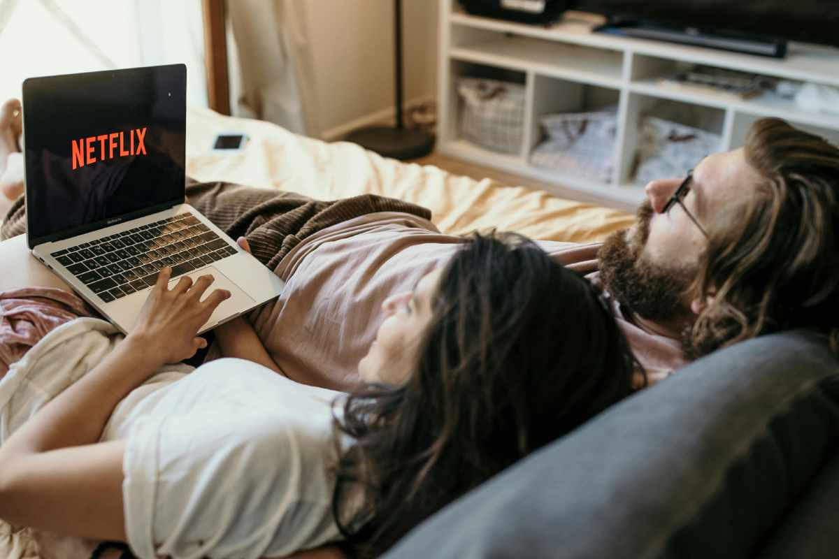 Una coppia stesa a letto che guarda Netflix dal tablet