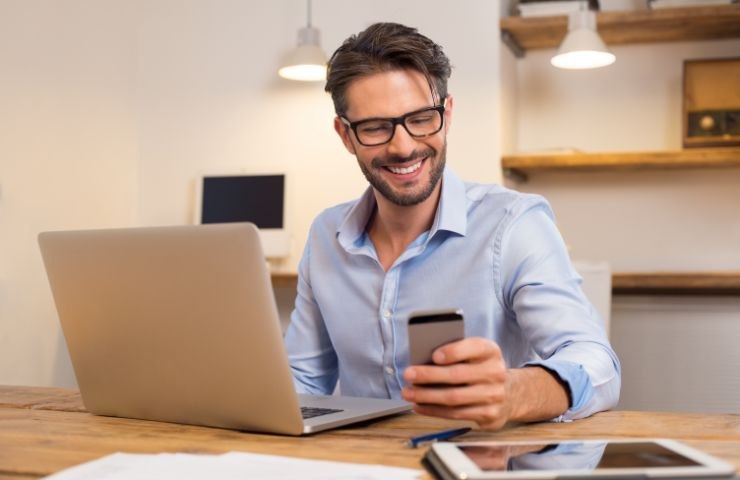 Uomo con smartphone e PC