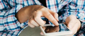 Donna con camicia a scacchi che usa il telefono