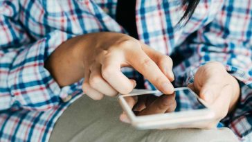 Donna con camicia a scacchi che usa il telefono