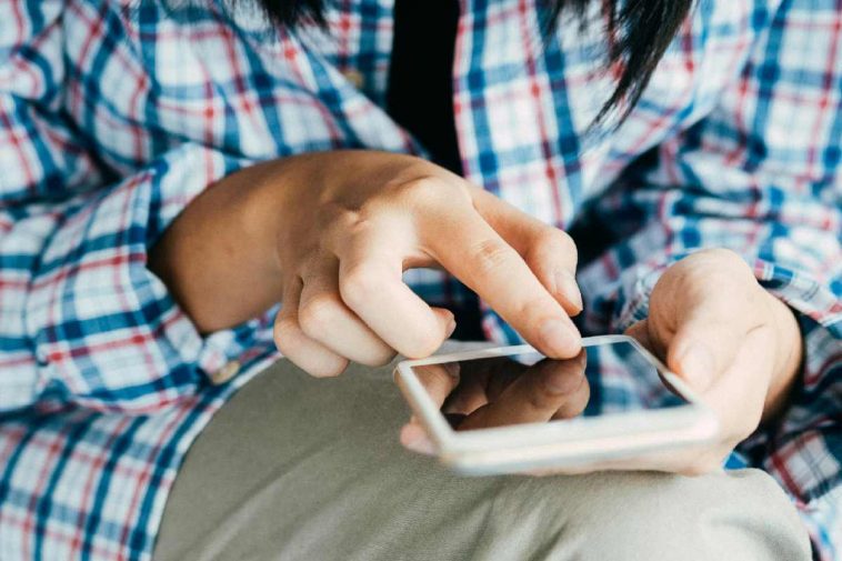 Donna con camicia a scacchi che usa il telefono