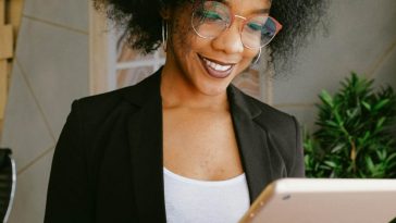 Una ragazza con gli occhiali che consulta un tablet in casa