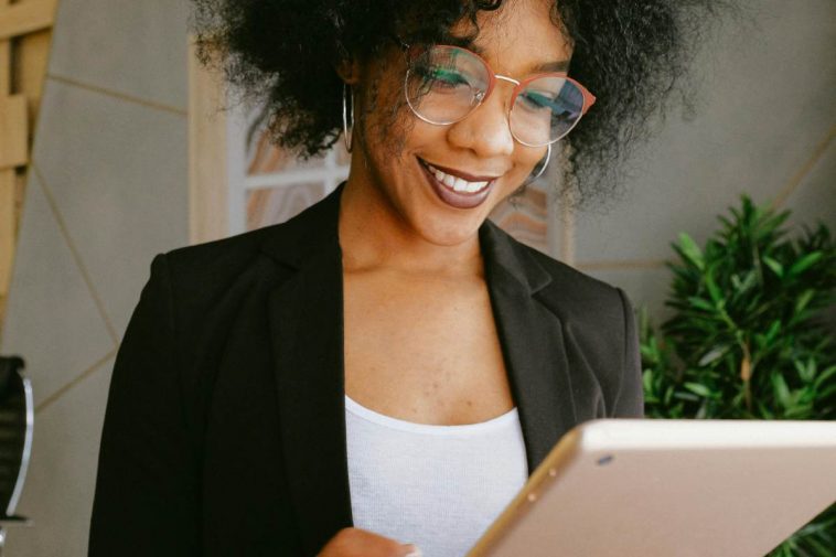 Una ragazza con gli occhiali che consulta un tablet in casa