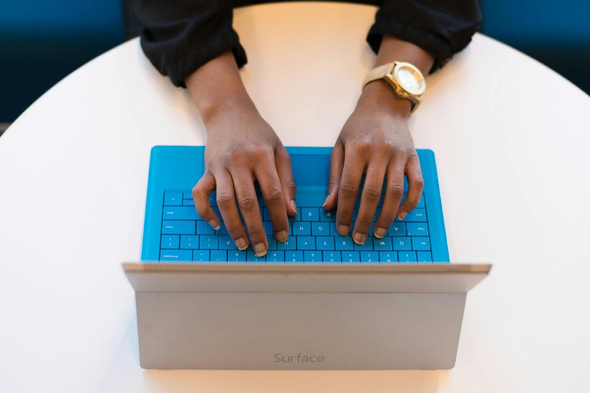 Un ragazzo che batte un testo sulla tastiera di un laptop