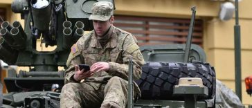 Un soldato seduto su un carrarmato fuori da un McDonalds