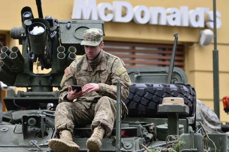 Un soldato seduto su un carrarmato fuori da un McDonalds