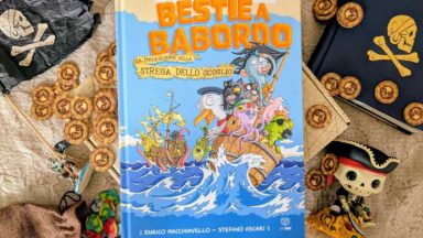 Il fumettogame Bestie a Babordo al centro di varie chincaglierie pirata: dobloni, bandiere, mappe
