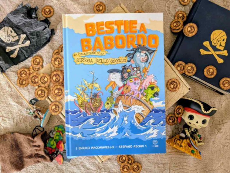 Il fumettogame Bestie a Babordo al centro di varie chincaglierie pirata: dobloni, bandiere, mappe