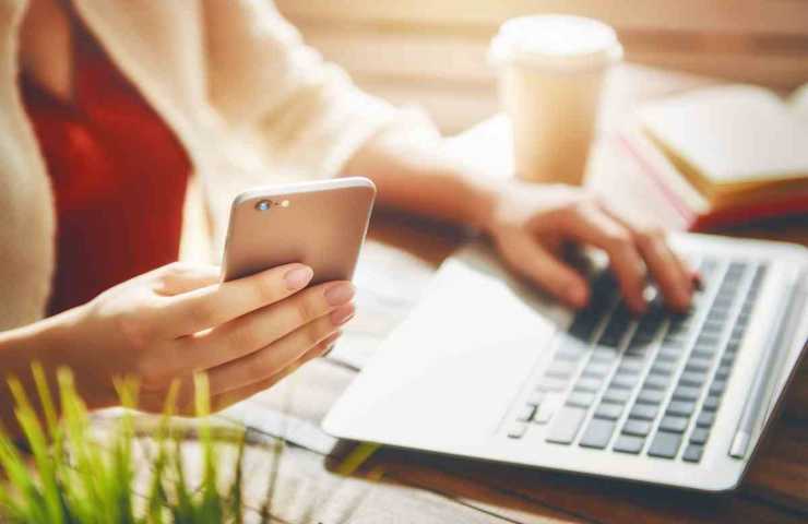 donna al pc con telefono