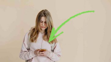 donna con telefono e freccia verde