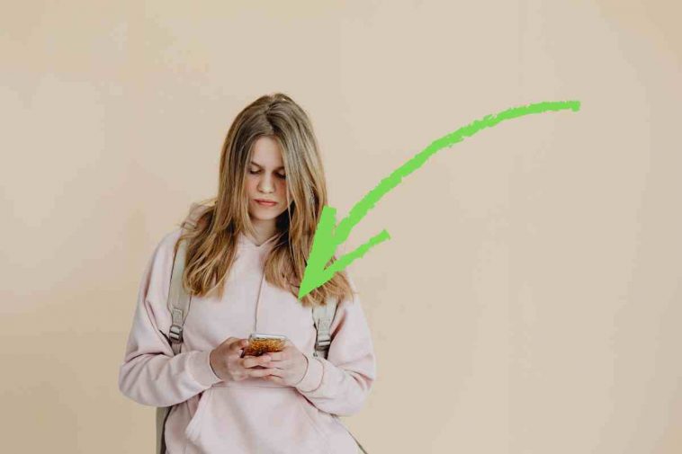 donna con telefono e freccia verde