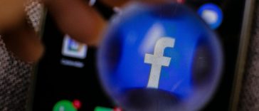 L'icona di Facebook ingrandita con una lente