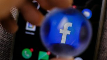 L'icona di Facebook ingrandita con una lente