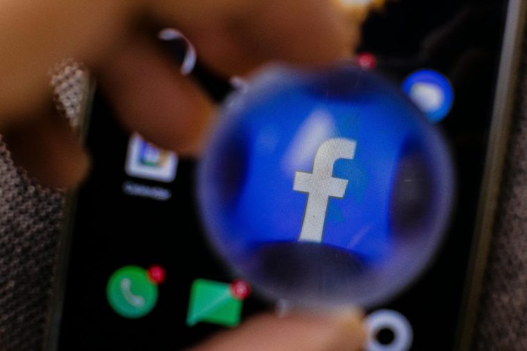 L'icona di Facebook ingrandita con una lente