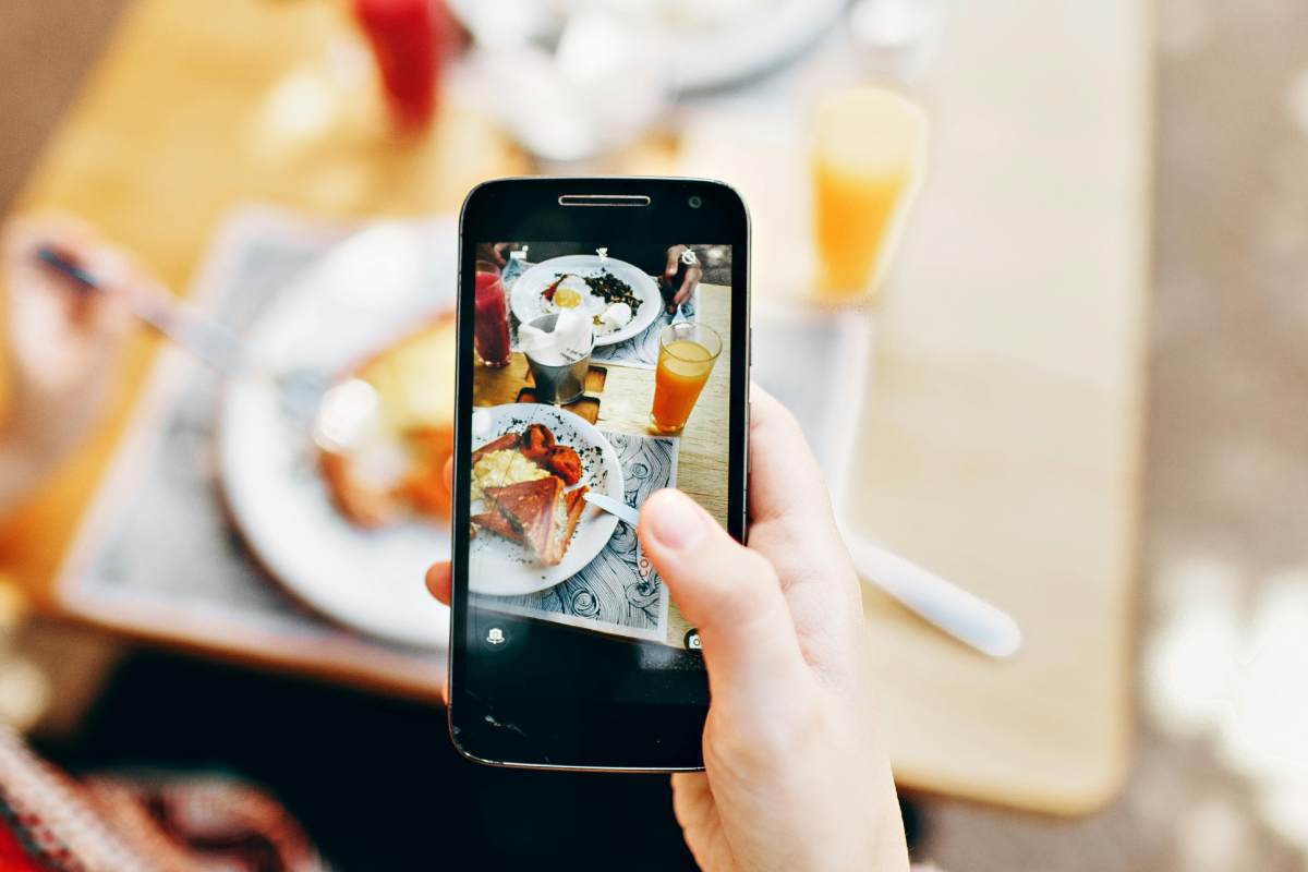 Un telefonino che fotografa una colazione