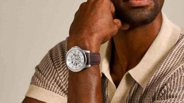 uomo con orologio al polso con polo