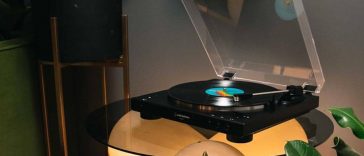 Audio-Technica AT-LP60XBT - Giradischi su tavolo di vetro in penombra